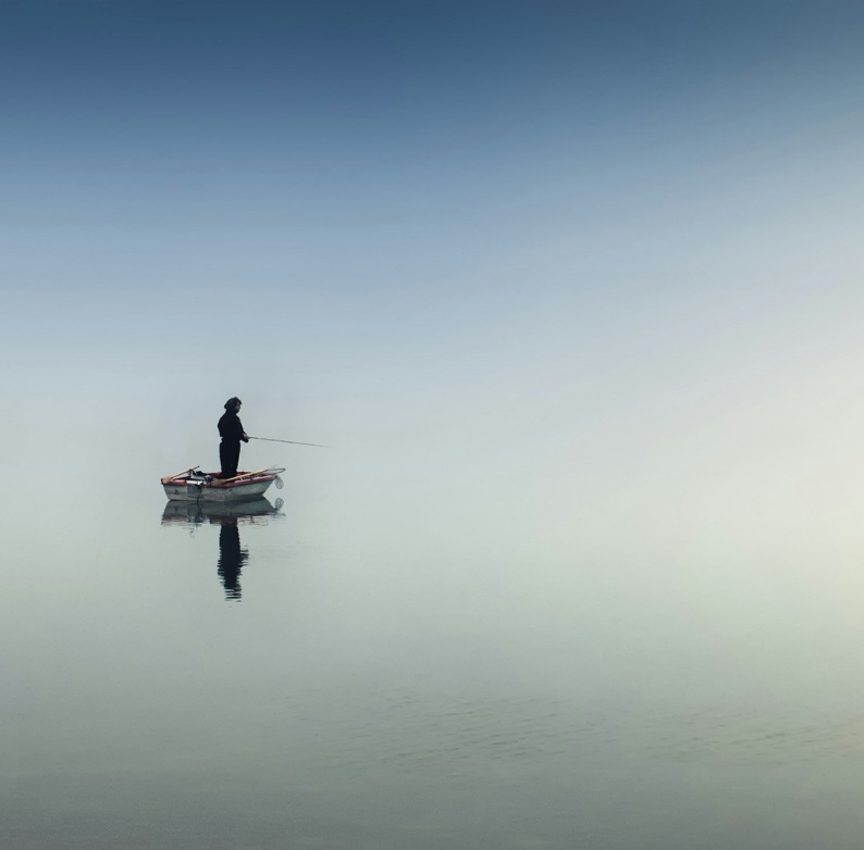 Ein Mann angelt auf einem ruhigen See